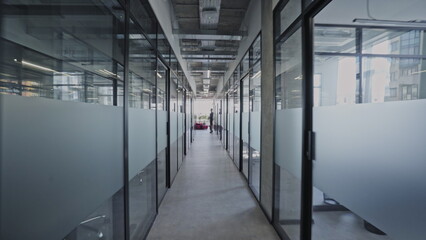 Long office corridor with many glass rooms, modern coworking space, business