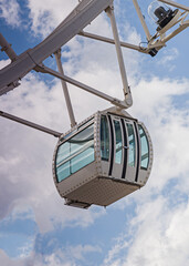 Einzelne Gondel eines Riesenrad mit bewölktem Himmel