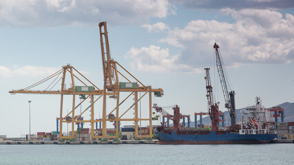 Hafen in Malaga mit blauem Frachtschiff und gelben Kränen