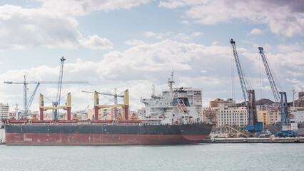 Hafen in Malaga mit Containerschiff das von Kr&auml;nen beladen wird