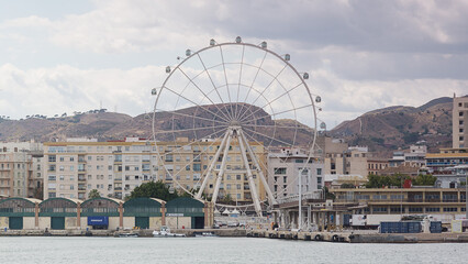 Riesenrad in Malaga, im Vordergrund LKW und im Hintergrund Stadtgeb&auml;ude