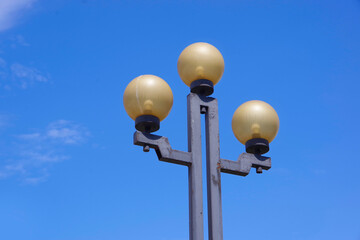 Three street lamps made of black metal.