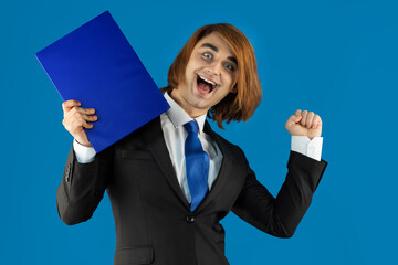 Young man rejoicing takes off his tie with relief. Prep Student with long hair wearing a formal...