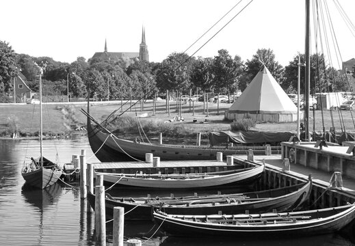 Monochrome Image of Moored Boats at the Viking Ship Museum's Pier with St. Luke Cathedral in the Backdrop, Roskilde, Denmark