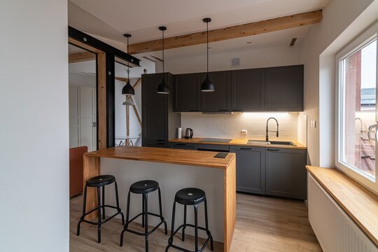 Dark gray kitchen furniture in a modern kitchen with a counter and bar tables