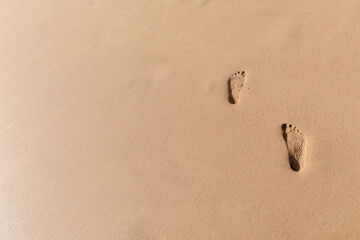 Fototapeta na wymiar Two footsteps in the sand on a walk in Maui Hawaii