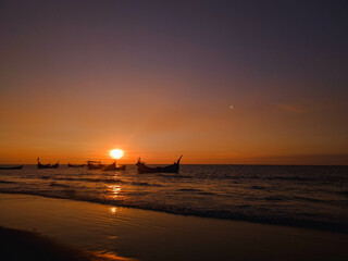 sunset on the beach or sunrise with boat on the sea
