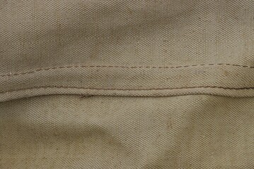 gray  fabric texture from an old dirty piece of tarpaulin and seam