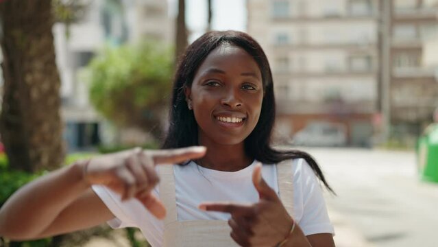 Young african american woman smiling confident doing photo gesture with hands at park