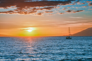 Fototapeta premium Maui Hawaii at sunset with a low sun and rocks and a mountain
