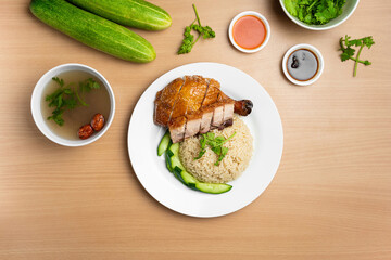 Roasted Chicken and Roast Pork Rice with raw cucumber, Coriander, salad, sauce and soup served in a dish isolated on wooden background top view