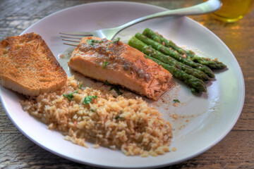 Side view of salmon dinner with anchovy garlic butter sauce