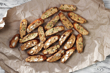 Top view of sliced freshly baked traditional homemade italian sweet cookies cantuccini on the paper and white wooden boards