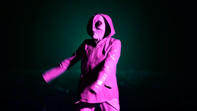 Hilarious alien dancing on dark backdrop. Funny meme footage of arrived on extraterrestrial planet masquerading as human person in smooth raincoat. UFO, fantasy, futuristic, fiction concept.