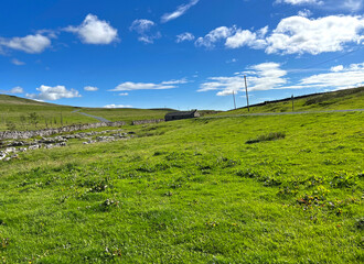 Landscape view, with the road to Settle, running past an old farm building near, Halton Gill, Skipton, UK