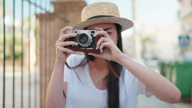 Young hispanic woman tourist smiling confident using camera at street
