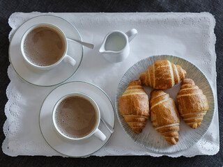 breakfast with coffee and croissant in hotel room