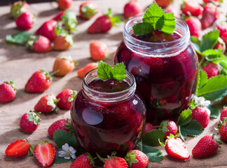 Homemade strawberry jam. Strawberries and jam jar on rustic table. Spring fruits.