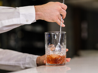 a bartender in the bar is preparing a cocktail