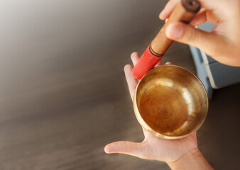 Man hands using singing bowl in sound healing therapy outdoors, closeup.