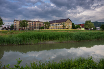 Fototapeta na wymiar Romania, Bistrita, School near the Bistrita River in June 2022