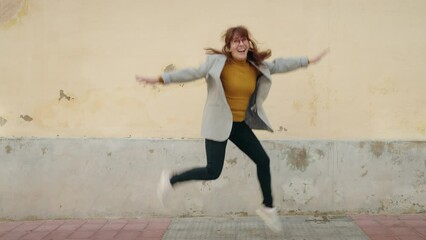 Middle age woman business executive jumping at street