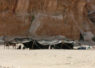 tents of a camp of a nomadic tribe near the Rocks in the desert of sand