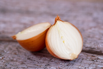 A halved onion on a wooden surface background.