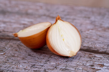 A halved onion on a wooden surface background.