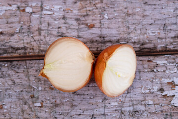 A halved onion on a wooden surface background.