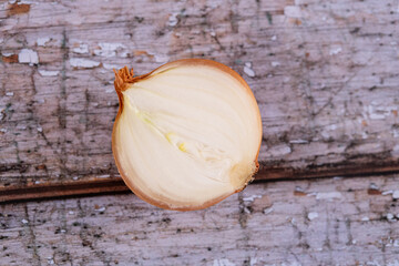 A halved onion on a wooden surface background.