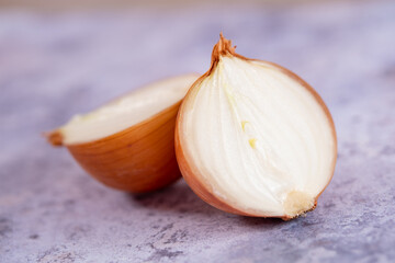 A halved onion on a marble surface background.