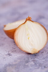 A halved onion on a marble surface background.
