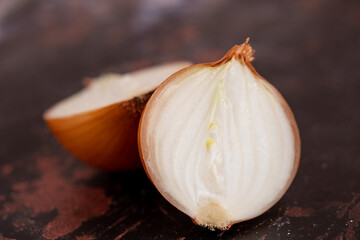 A halved onion on a black metal surface background.