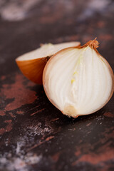 A halved onion on a black metal surface background.