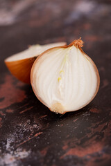 A halved onion on a black metal surface background.