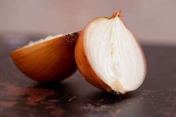 A halved onion on a black metal surface background.