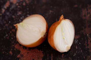 A halved onion on a black metal surface background.