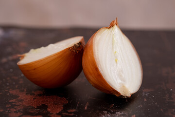 A halved onion on a black metal surface background.