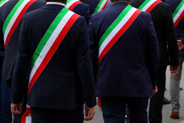 elegant Italian mayors during the event with the green white and red tricolor band