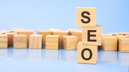 SEO. wooden cubes. blocks lie on a black background. stacks with coins. inscription on the cubes is...