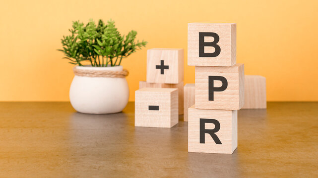 text BPR - written on the wooden cubes in black letters, the cubes are located on a yellow surface. concept word forming with cubes on background. BPR - Business Process Reengineering