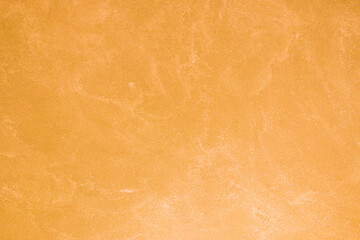 Texture of old orange plaster damaged by weather.