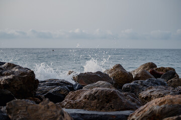 Sea waves lash line impact rock on the beach