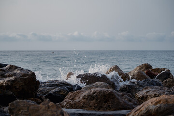 Sea waves lash line impact rock on the beach