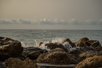 Sea waves lash line impact rock on the beach