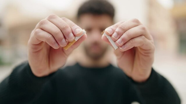 Young arab man breaking cigarette at street