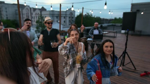 Female celebrity influencer posing POV selfie at summer outdoor night roof party dancing friends