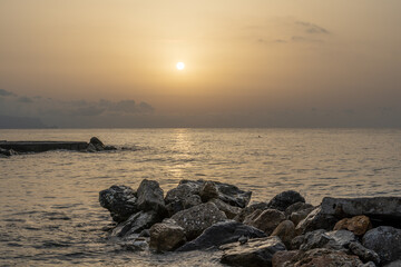 Fototapeta na wymiar Sonnenuntergang am Meer in Italien. Vielfalt der Farben und Farben der aufgehenden Sonne. Meereslandschaft mit Wasser und Steinen.
