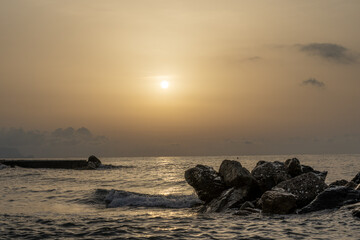 Fototapeta na wymiar Sonnenuntergang am Meer in Italien. Vielfalt der Farben und Farben der aufgehenden Sonne. Meereslandschaft mit Wasser und Steinen.